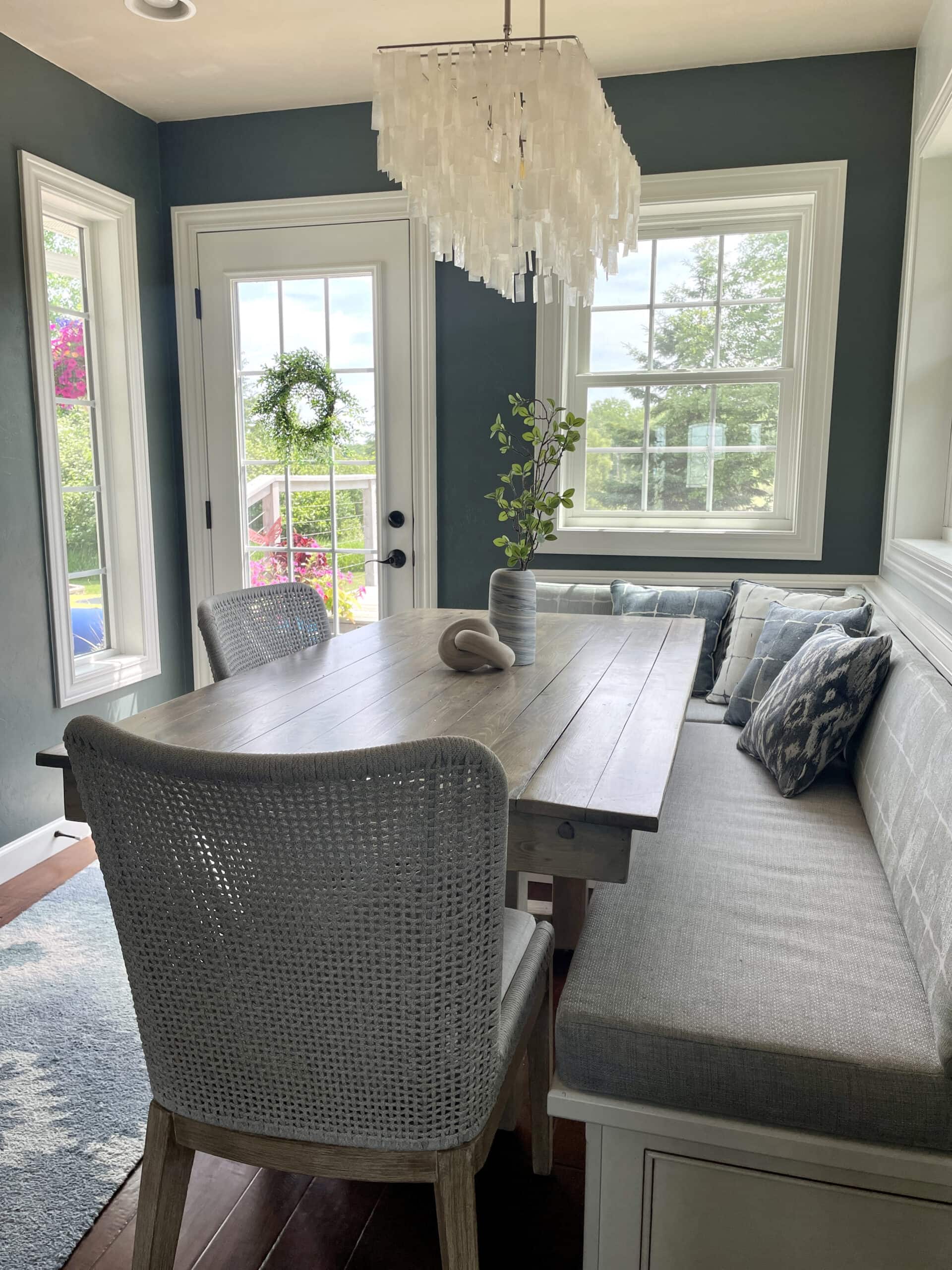 Breakfast nookwith table, rope dining chairs, bench seating with a path to a patio door.