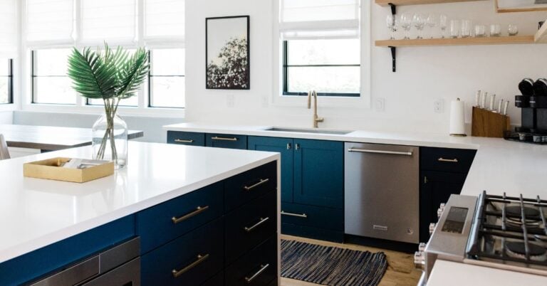 Coastal decorating kitchen with bold blue lower cabinets, white countertops, wood accents, and woven textures