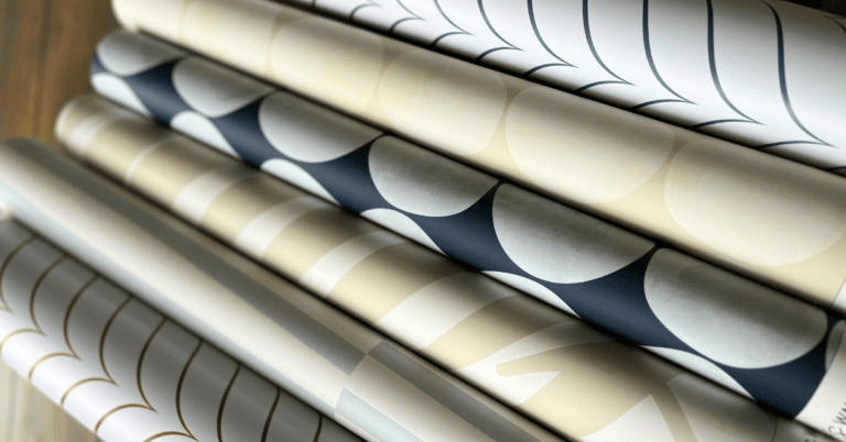 A collection of rolled coastal wallpaper styles in soft neutral tones and geometric patterns, perfect for adding texture and personality to any space.