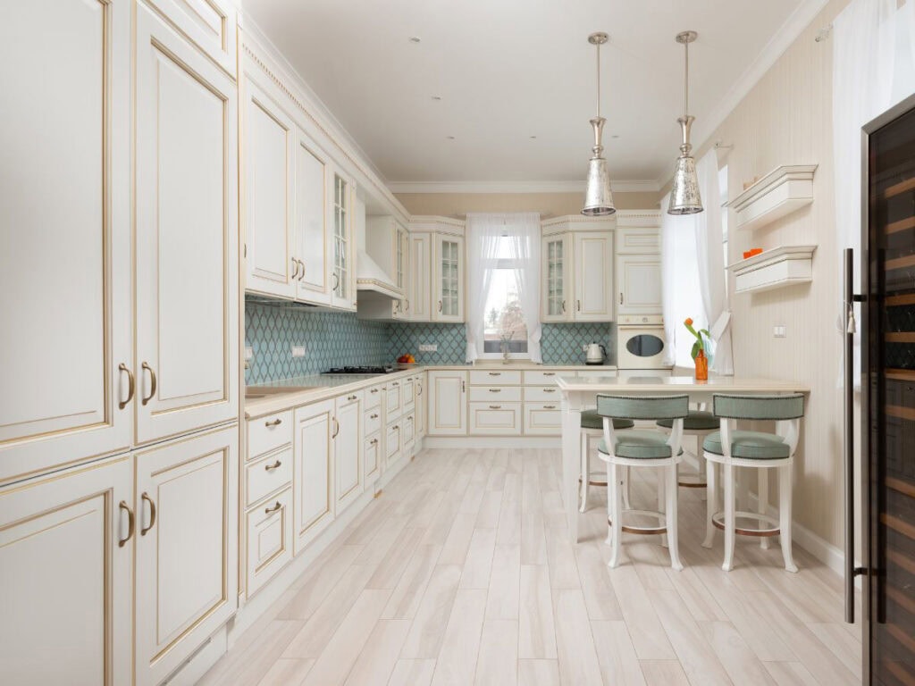 Light coastal kitchen with Aquaverde green upholstered bar stools and coordinating backsplash accents