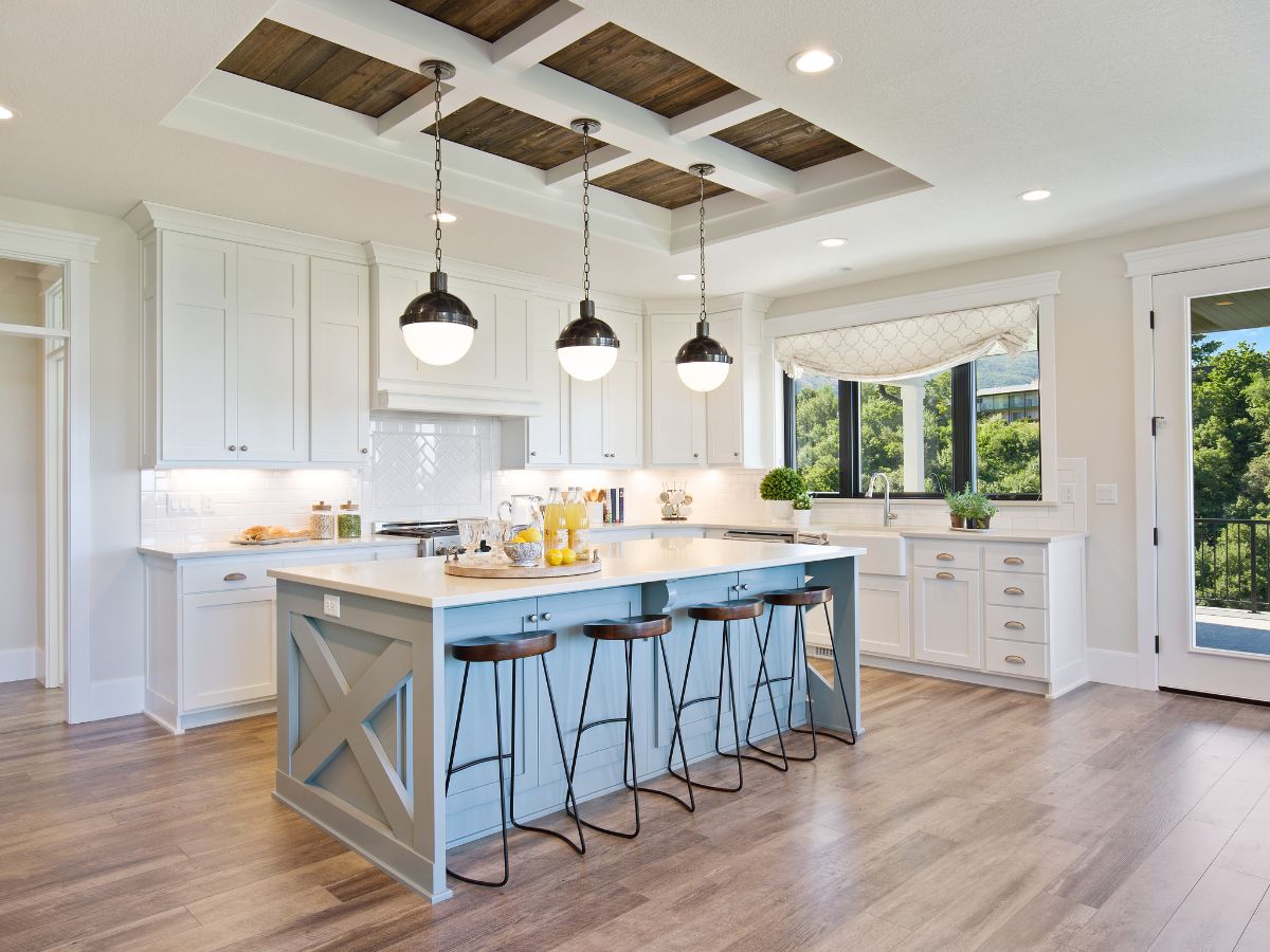 Coastal-style kitchen with soft white painted cabinets and light blue island for a two tone cabinetry finish.