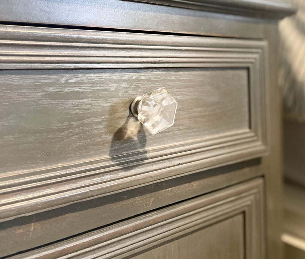 Softly painted cabinet drawer with a clear glass knob and coastal-inspired detailing