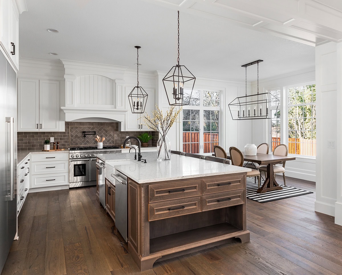 Kitchen with white perimeter cabinets and a stained wood island in a bright, natural-light space.