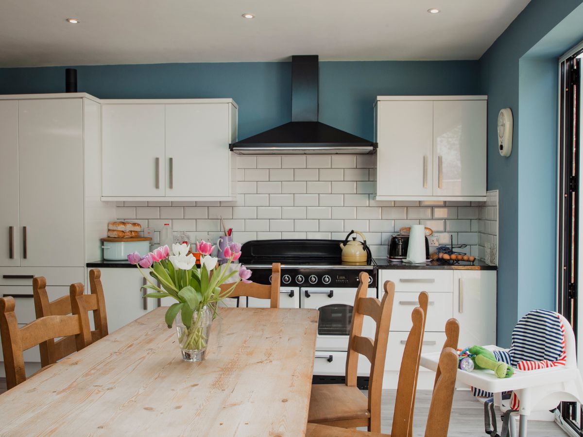 Cozy kitchen with blue wall paint, white cabinets, and subway tile backsplash