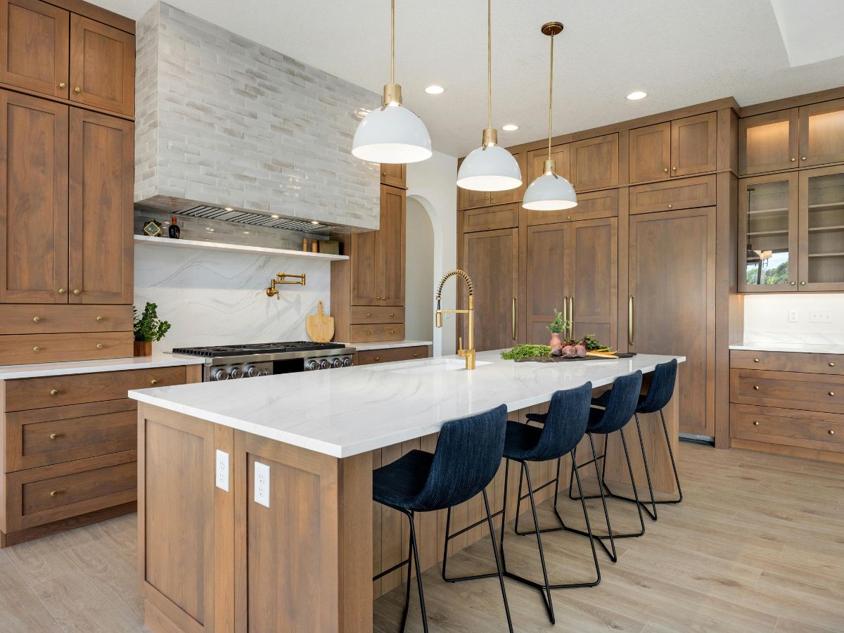 Kitchen with rich wood cabinetry, white countertops, and brass fixtures