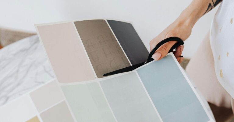 Hands selecting and cutting paint swatches with interior samples