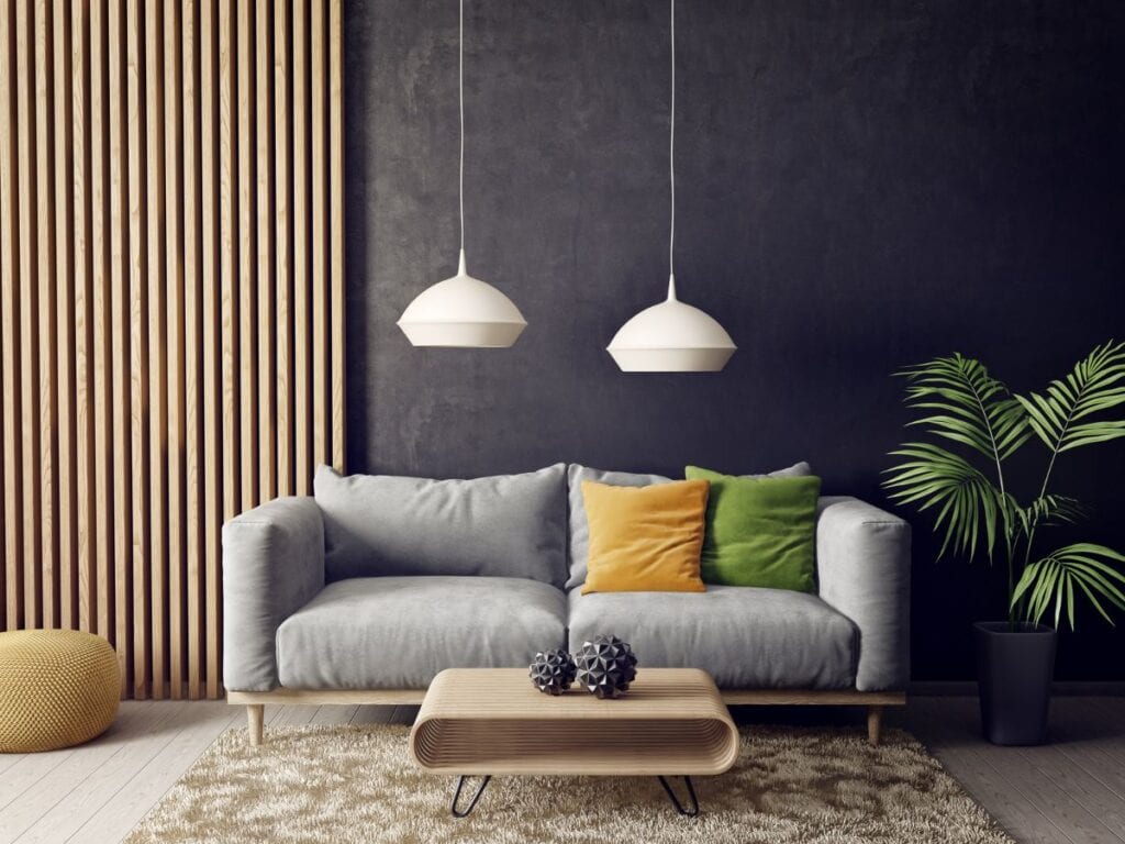 Moody living room with dark charcoal wall, natural wood accents, and colorful throw pillows