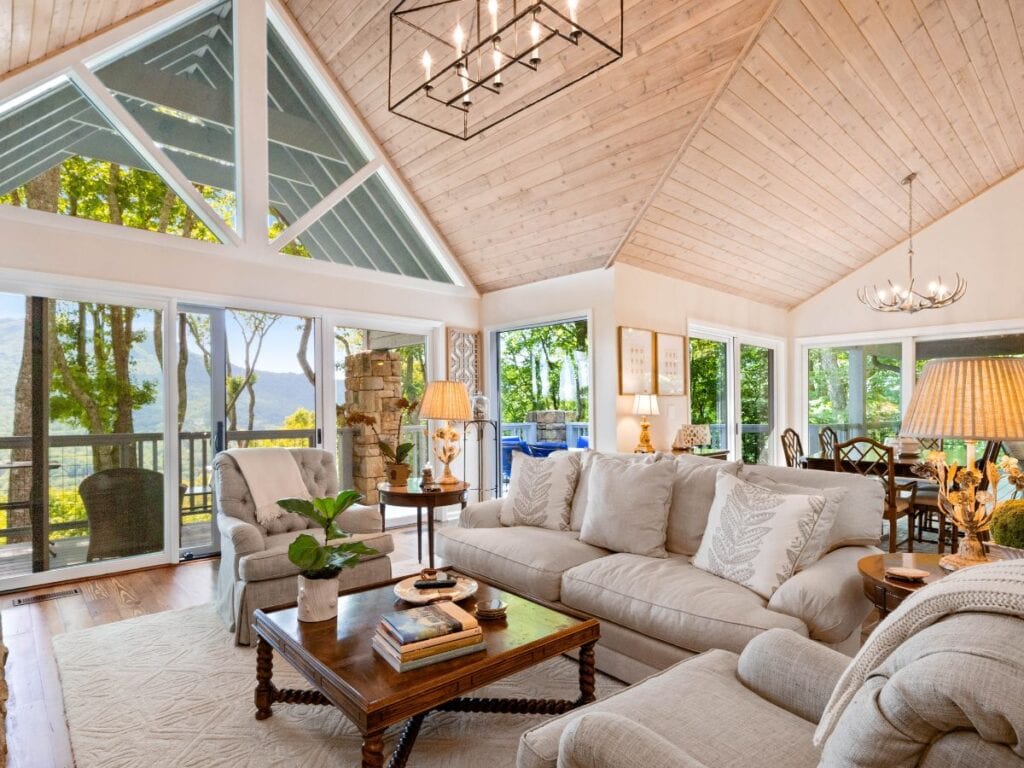 Living room with warm wood ceiling, oak floors, and neutral upholstery showing why it’s best to avoid overusing the same tone on walls when choosing interior paint colors.