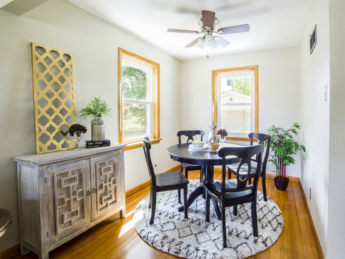 Dining nook with small round rug under table and chairs; rug is too small to support pulled-out chairs, highlighting a common floor plan and rug placement mistake.