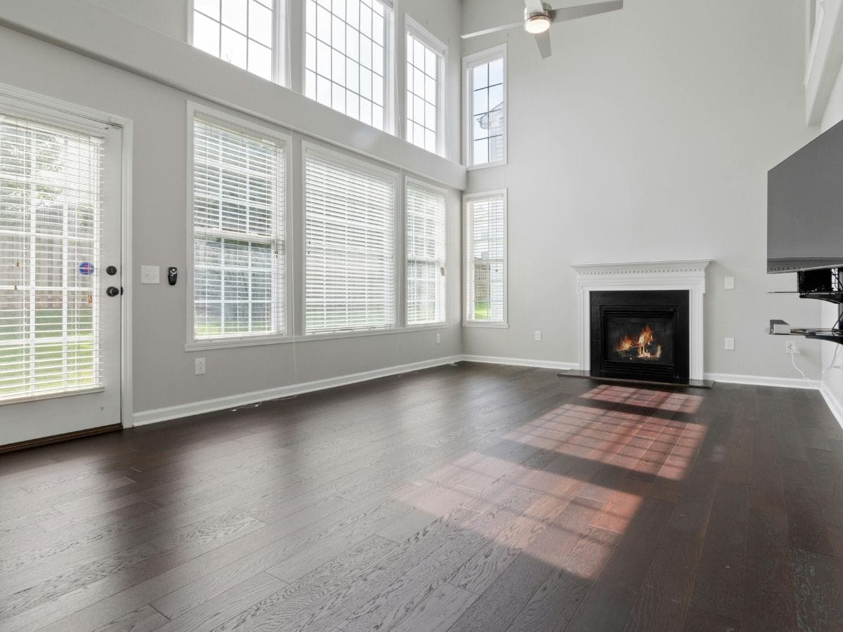 Empty living room with fireplace and backyard door—ideal for planning new furniture layout and rug placement.
