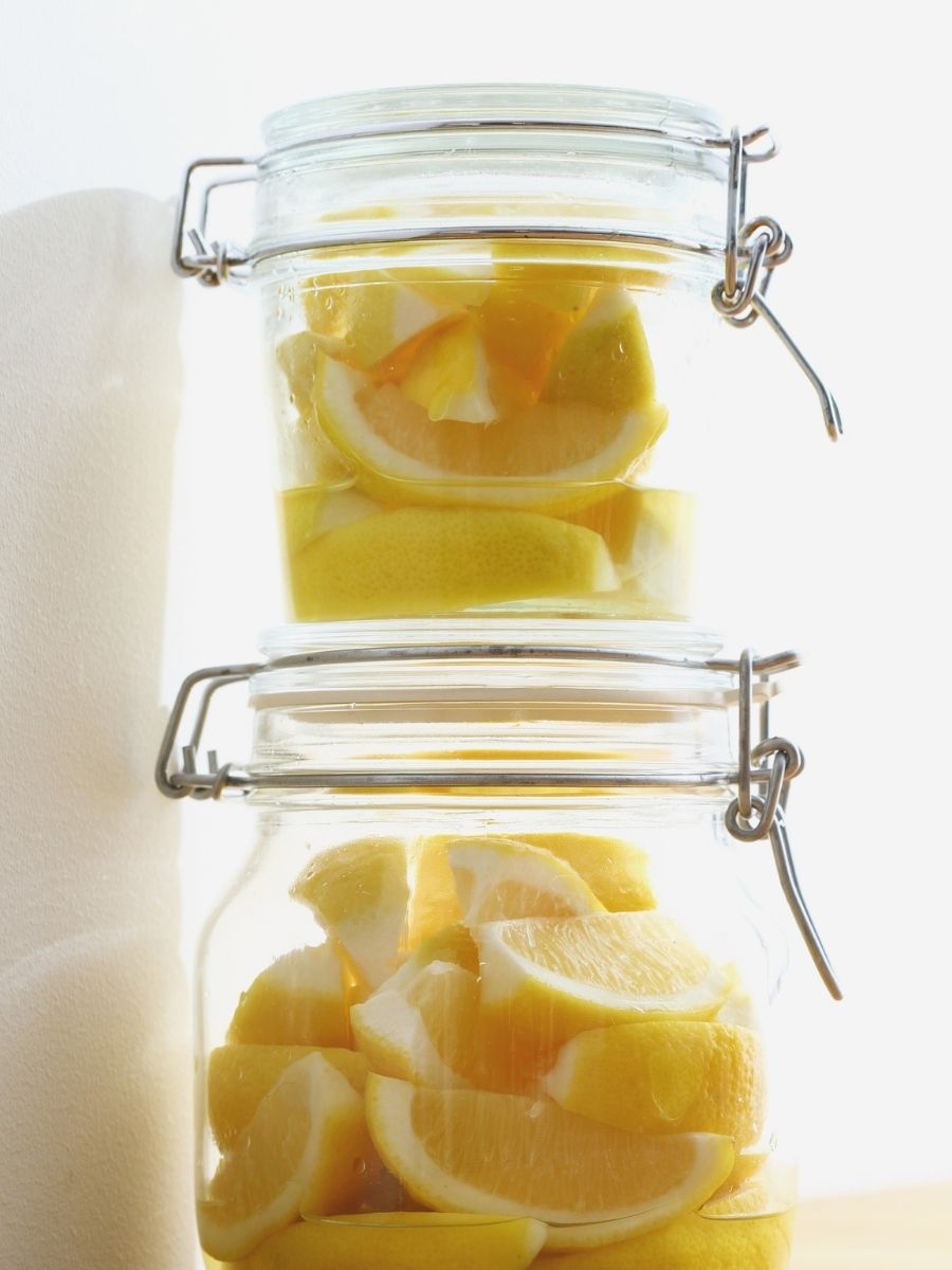 Glass jars filled with sliced lemons for lemon home decor, summery styling, and fresh citrus inspiration.