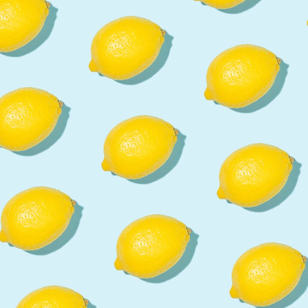 Bright yellow lemons on a blue background for bold lemon wallpaper ideas in coastal home decor.