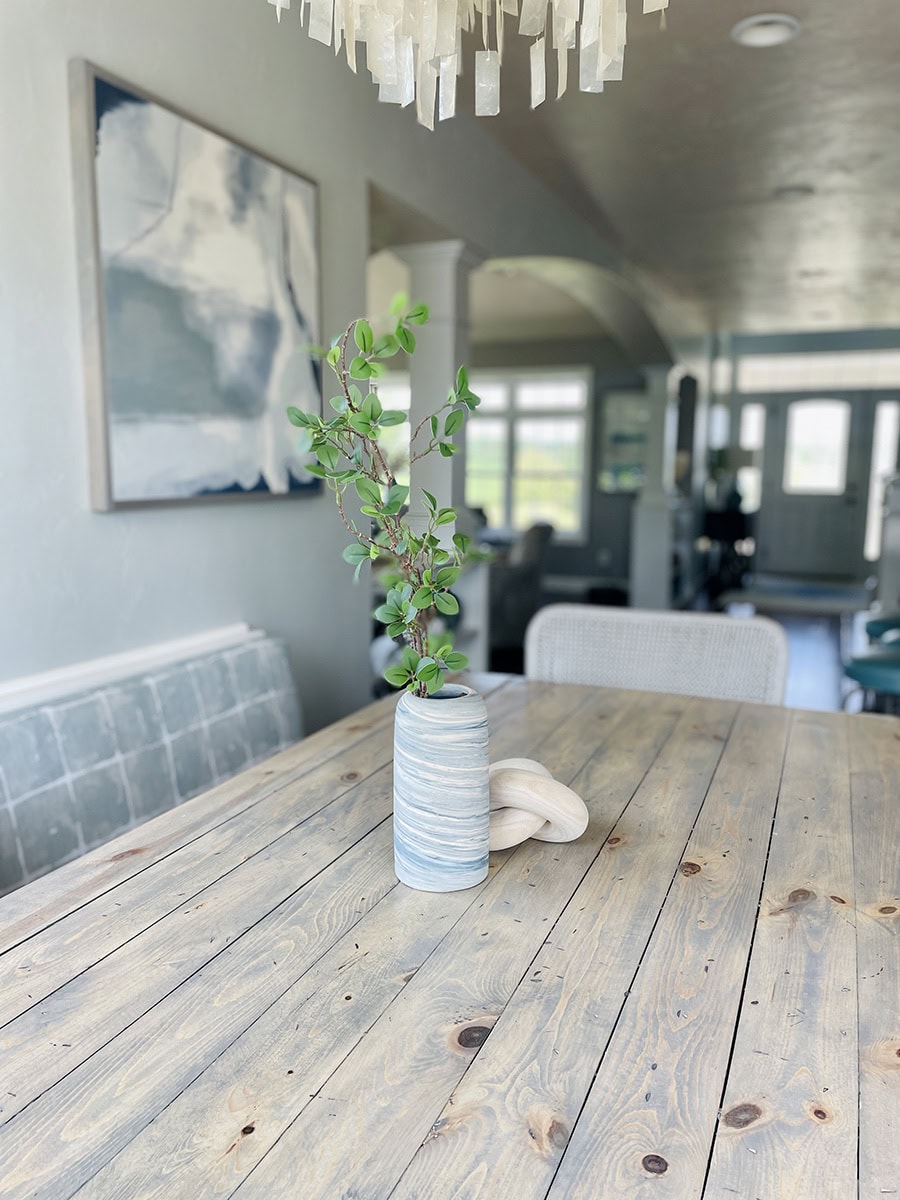 Dining nook painted in SW Silver Strand with natural wood table, capiz chandelier, and coastal decor accents