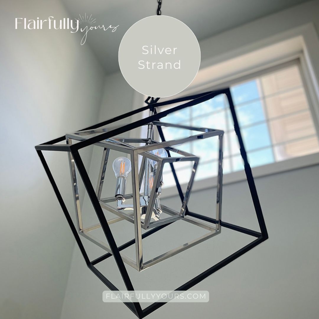 Modern foyer painted SW Silver Strand with geometric light fixture, showing chameleon paint color’s soft glow.