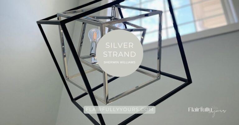 Modern black and silver geometric light fixture against walls painted in SW Silver Strand, a coastal chameleon paint color from Sherwin Williams.