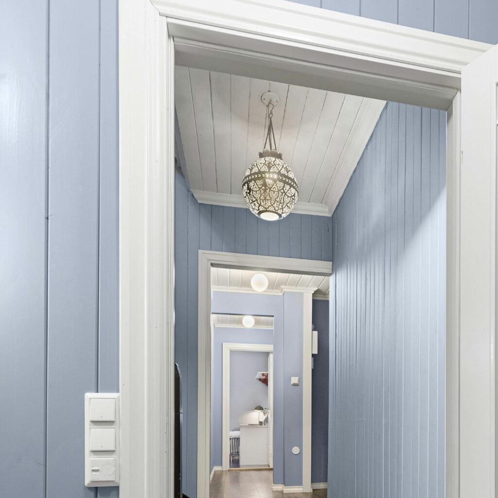 Hallway with soft blue walls and crisp white trim, showing how white trim frames coastal colors beautifully.