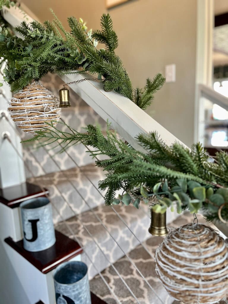 Christmas garland on staircase with brushed brass bells for metallic accents