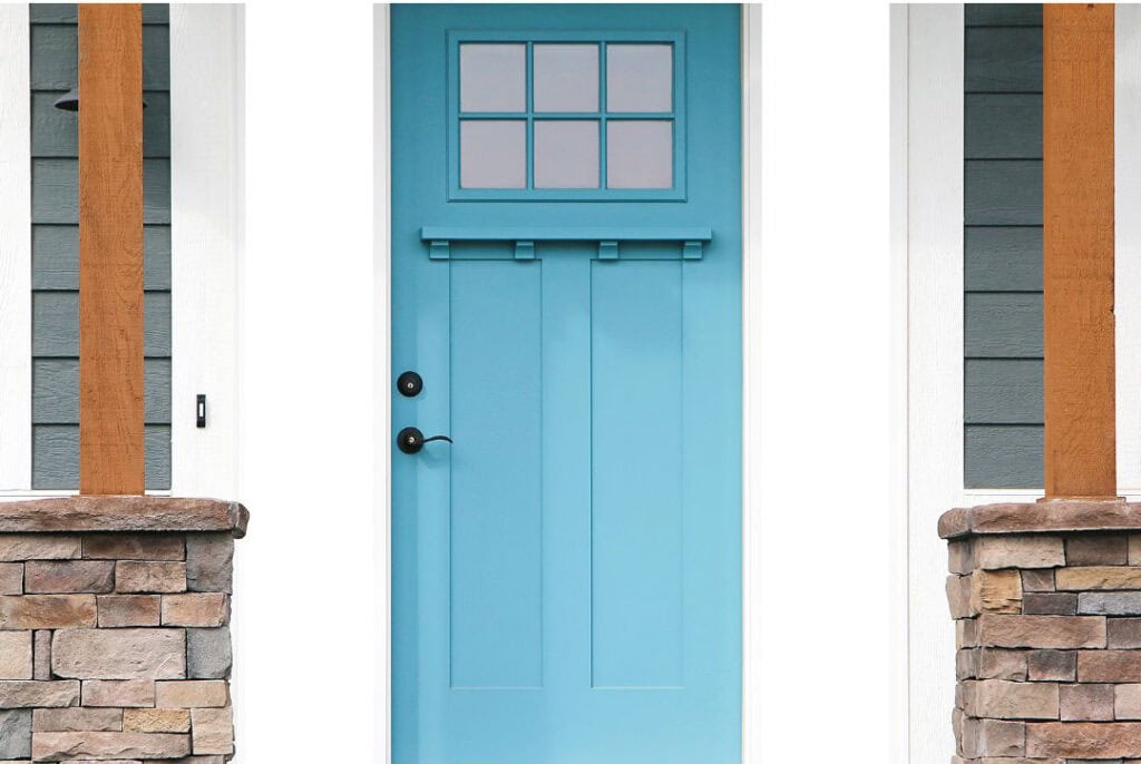 Bright sky-blue front door with white trim on a coastal exterior, demonstrating a playful beach house accent color.