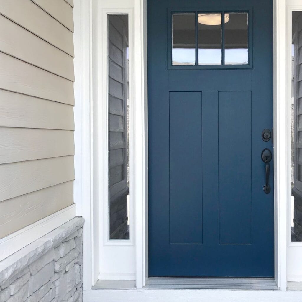 Navy blue front door with white trim on a beach house exterior, showing how coastal accent colors add contrast and personality.