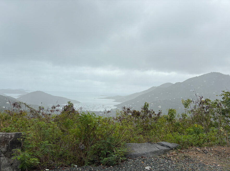View from the Ram Head Trail, overlooking the island with lush greenery and ocean in the distance, St. John, USVI.