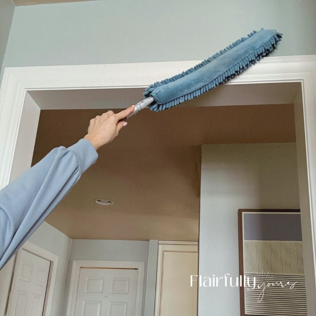 A hand using a microfiber duster to clean trim during a spring clean-up.