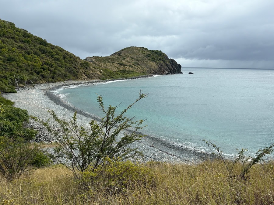 Panoramic view of Blue Cobblestone Beach, St. John, with crystal-clear waters and rugged coastline.