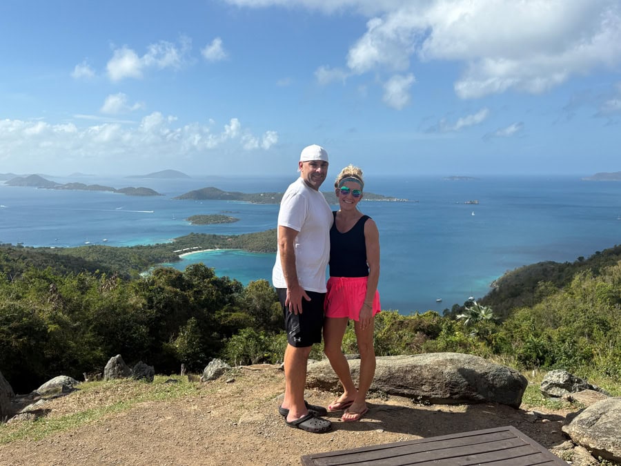 A panoramic view of St. John from the Windmill Bar showcasing vibrant blues and lush green hills meeting the ocean.