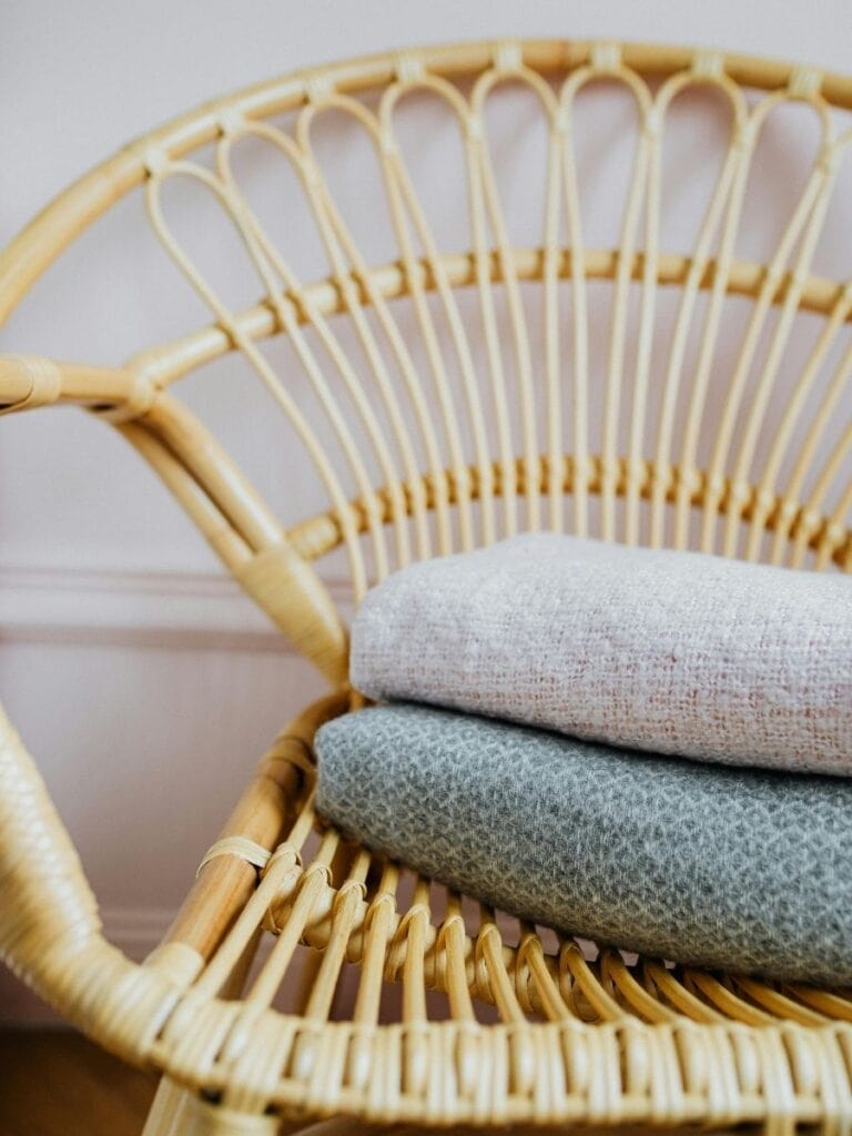 A coastal boho chair with woven fabric and natural textures, showcasing how boho coastal decor mixes earth tones with light, relaxed coastal vibes.