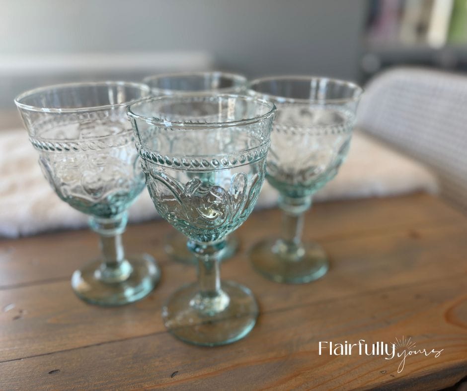 Aqua glass goblets on a wooden table, adding a fun pop of color to everyday dining.
