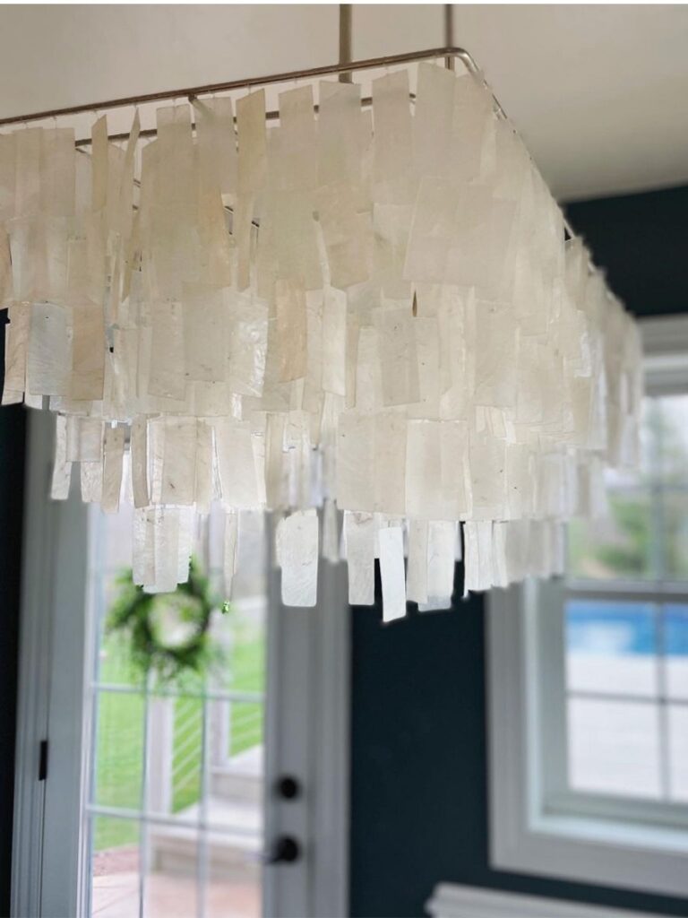 Capiz chandelier with soft, translucent shells, casting a warm and inviting glow over the dining area.