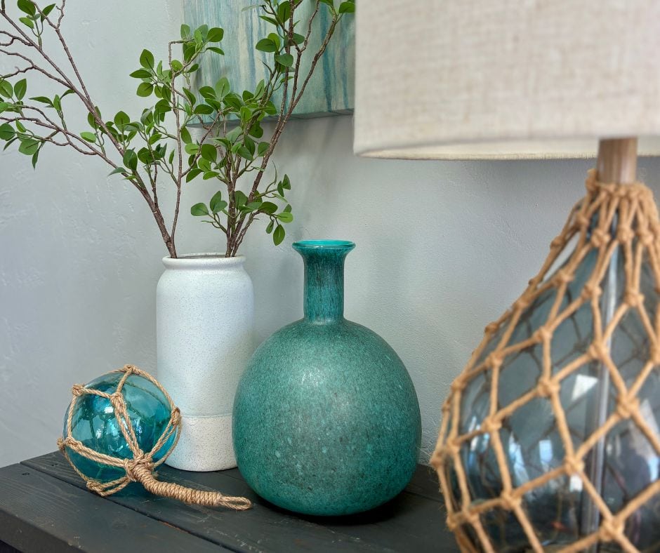 Coastal-inspired decor with teal vases and greenery, perfect for adding a pop of spring color and freshness to your home.