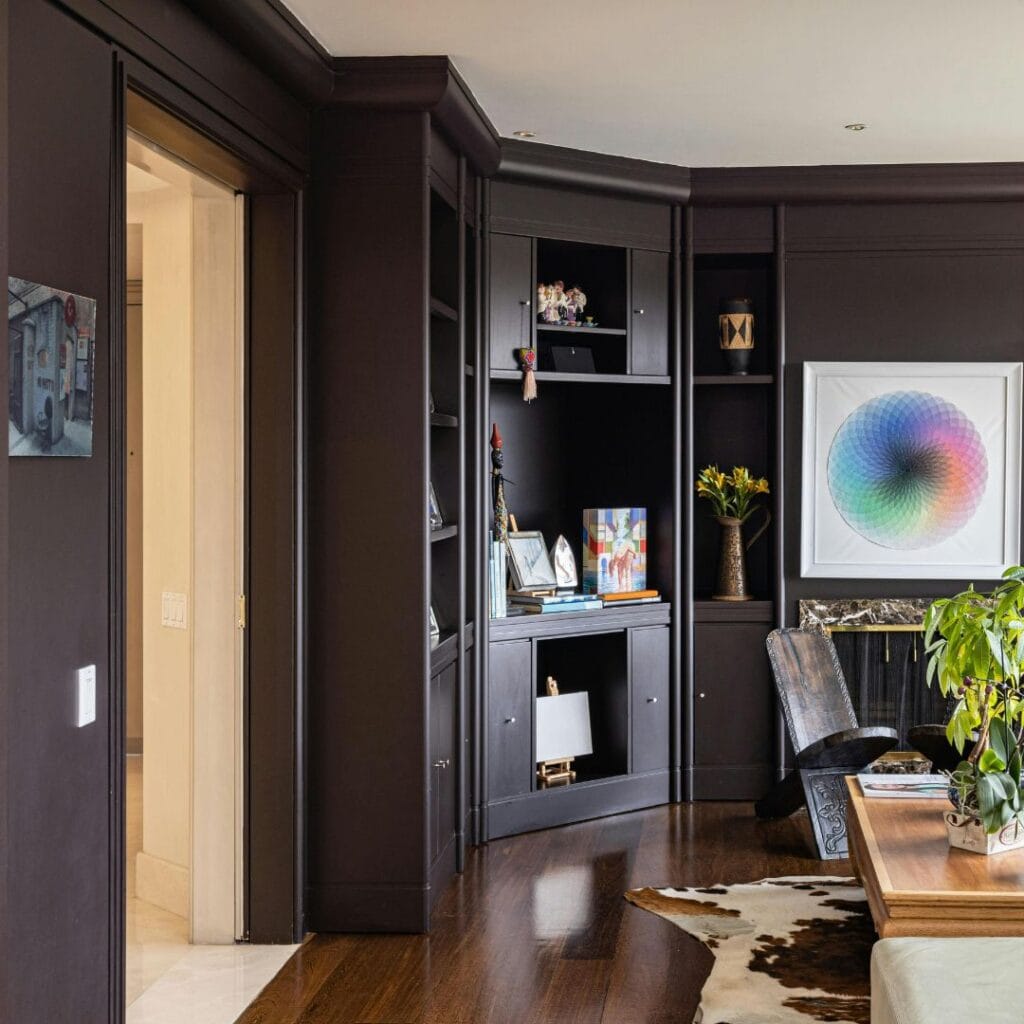 Dark trim creates bold contrast against rich, dark walls for a refined, cohesive look in high-ceilinged spaces.