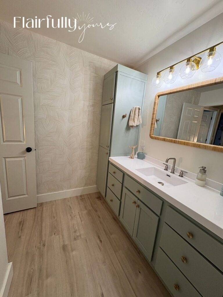 Finished bathroom wall featuring palm print wallpaper, adding a coastal charm with a subtle linen texture.