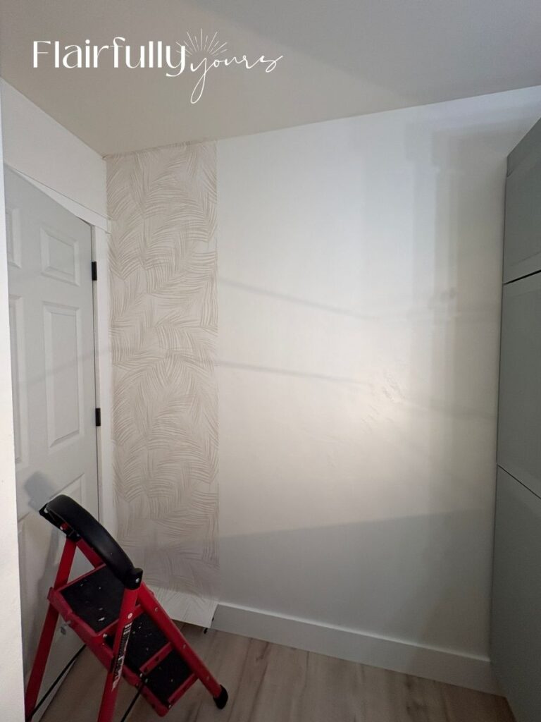 Applying traditional glue palm wallpaper to a bathroom wall, showcasing the neutral linen pattern.