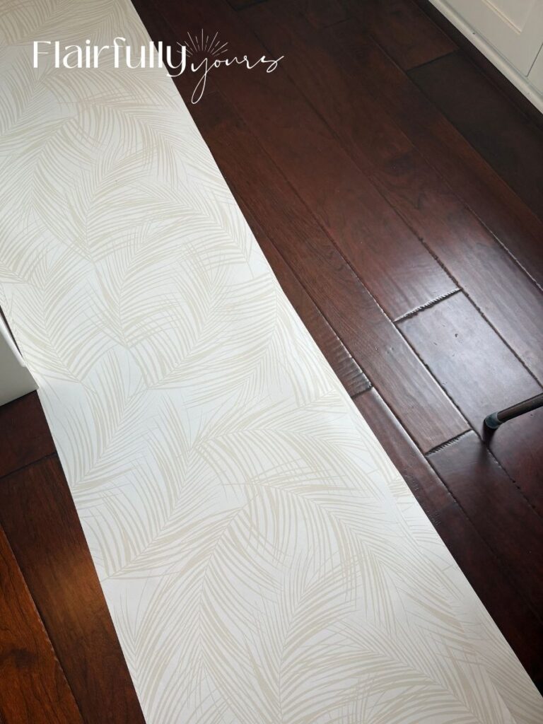 Peel-and-stick palm wallpaper laid flat, allowing it to acclimate to the temperature and humidity of the room before application.