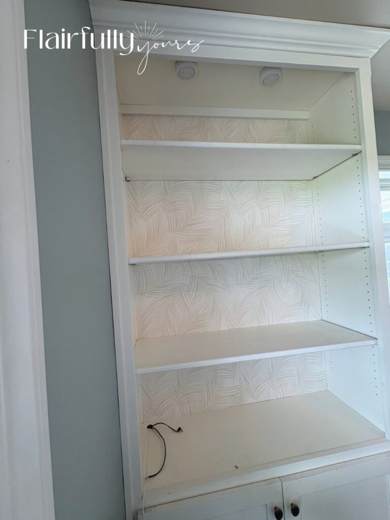 Finished peel-and-stick palm wallpaper on the back of shelves with clean, trimmed edges.