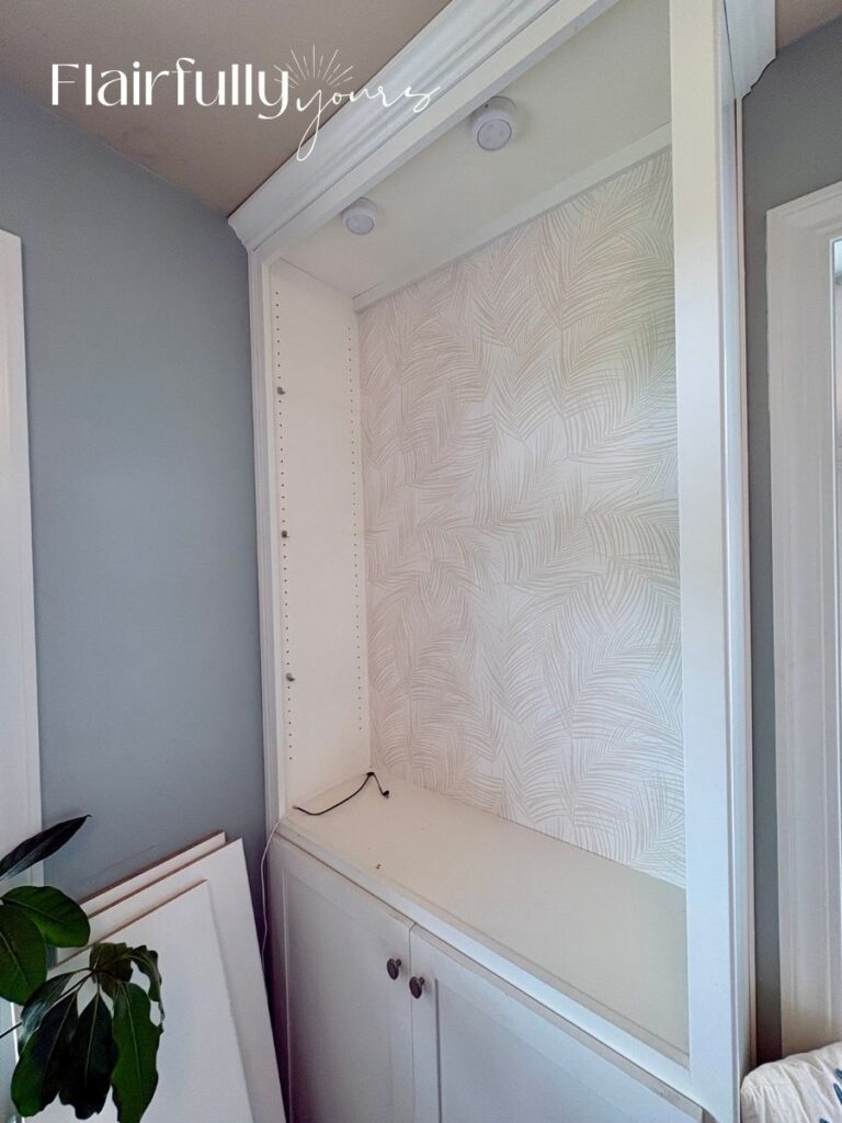 Palm print wallpaper used behind office shelves, creating a breezy, coastal vibe with soft linen texture and off-white background.