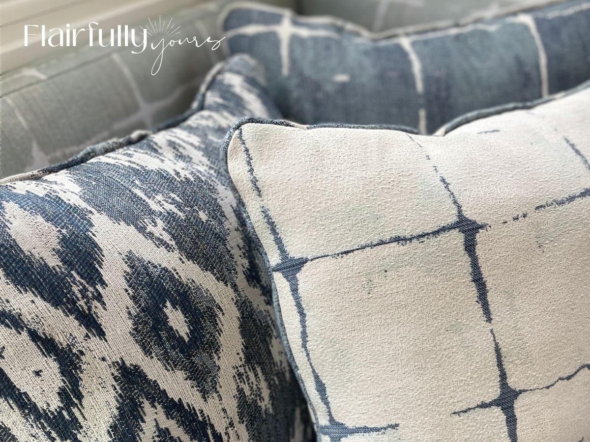 Close-up of subtle blue and white patterned pillows with natural textures, ideal for a coastal design.