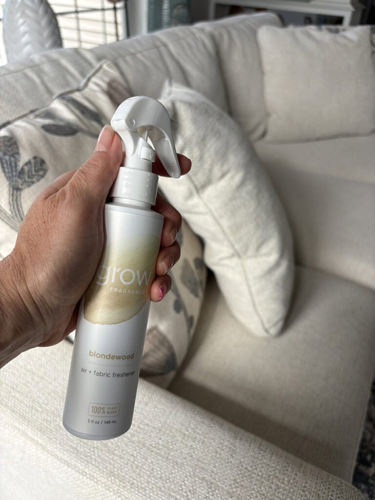 Grow Fragrance Blondewood Air + Fabric Spray being used on a living room sofa.
